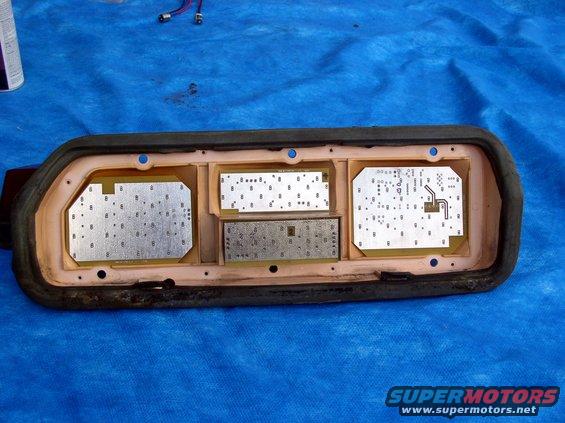 Car dashboard instrument cluster circuit boards on a blue tarp