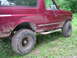 1994 Ford Bronco - A maroon Ford Bronco is shown from the front quarter, covered in mud from off-road use.