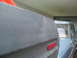 1979 Ford Bronco - Close-up of a gray panel with a red reflector, adjacent to the side of a blue truck.