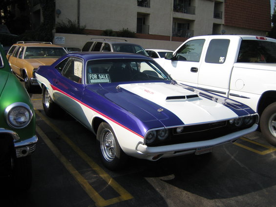 Purple and white Dodge Challenger with a 'For Sale' sign in the window