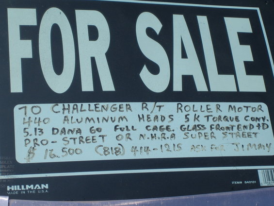 Black sign with large white 'FOR SALE' text and handwritten details about a 70 Challenger R/T