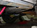 1985 Ford Crown Victoria LTD - Underbody view of a vehicle, a Canton brace and a tire, with a red jack and soil bags visible.