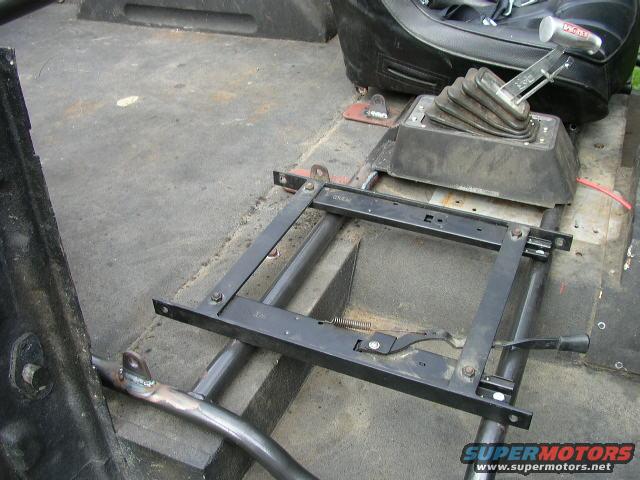 Vehicle interior showing a floor-mounted shifter and seat mounting hardware