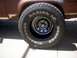 1986 Ford Bronco II - Close-up of a tire and fender on a vehicle, showing rust and wear on the body.