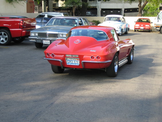 red classic sports car parked, other cars behind it
