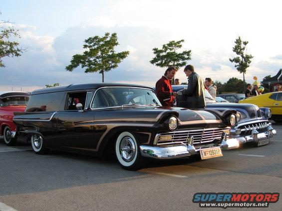 Dark 1957 sedan delivery van with whitewall tires and chrome grille