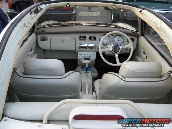 Interior of a white convertible with cream leather seats and a white steering wheel