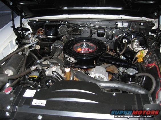Engine bay with a black air cleaner labeled "Jetfire", showing hoses, belts, and a radiator