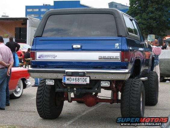 Rear view of blue lifted Chevrolet K5 Blazer with large tires and custom decals