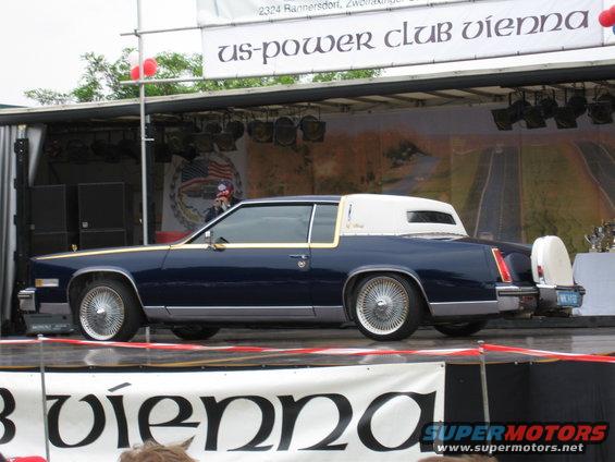 Dark blue coupe with white vinyl roof and continental kit, side view