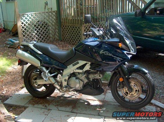 Dark blue Suzuki V-Strom motorcycle parked outside next to a green SUV