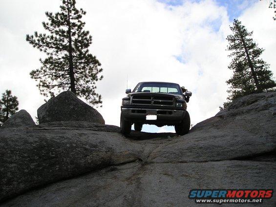 Dodge Ram truck climbing over large rocks on a mountain trail