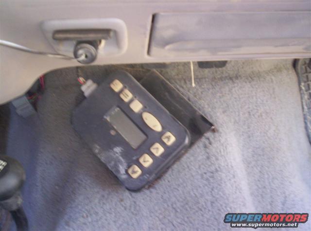 Aftermarket controller with buttons and a small screen on a carpeted floor