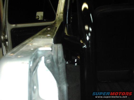 Interior of a vehicle showing a roll cage and door frame