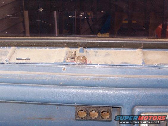 Blue interior panel with metal latch mechanism and three circular buttons. Supermotors.net logo visible