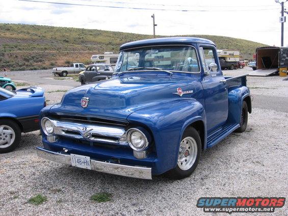 Blue 1956 Ford F-series pickup truck parked next to a blue car