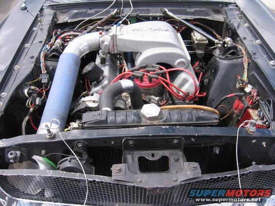 1972 Ford Mustang engine bay with V8 engine and blue intake hose