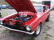 1972 Ford Mustang - Red 1970 Ford Maverick coupe with its hood open, revealing the engine bay. A trailer is visible in the background.