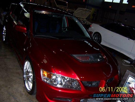 Red sedan with hood scoop and custom wheels