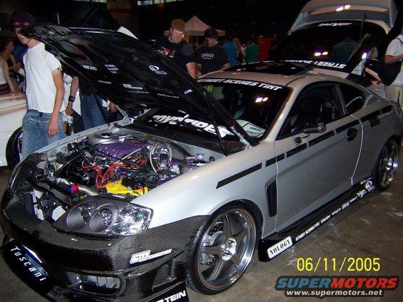 Silver coupe with hood open, custom engine, and racing decals. Date stamp reads 06/11/2005