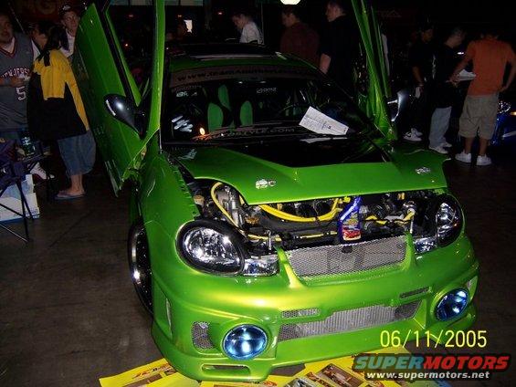 Green car with butterfly doors open, engine exposed. Date stamp says 06/11/2005