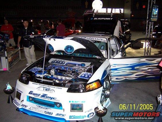 modified car with flames on door, open hood showing engine, and custom interior. Date stamp shows 06/11/2005