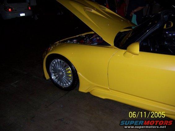Yellow sports car, front quarter view, hood open showing engine, custom body kit, aftermarket wheels. Date stamp 06/11/2005