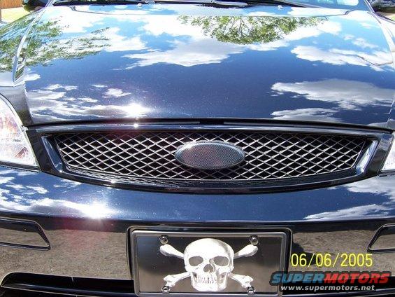Black Ford Focus front grille with a skull and crossbones license plate frame. Date 06/06/2005 visible