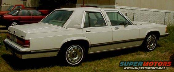 1990 Mercury Grand Marquis parked on grass with a red car and truck behind it
