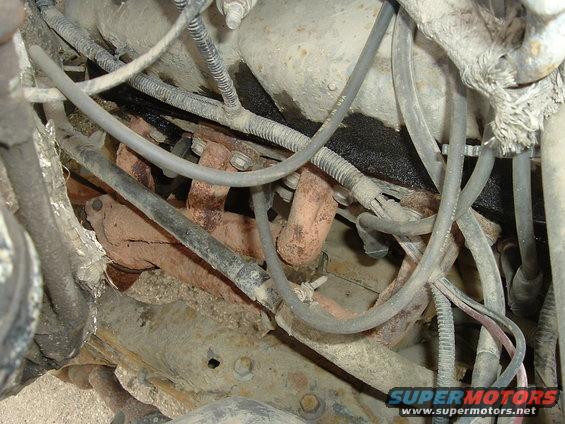 Engine exhaust manifold with rusty pipes and wiring harnesses