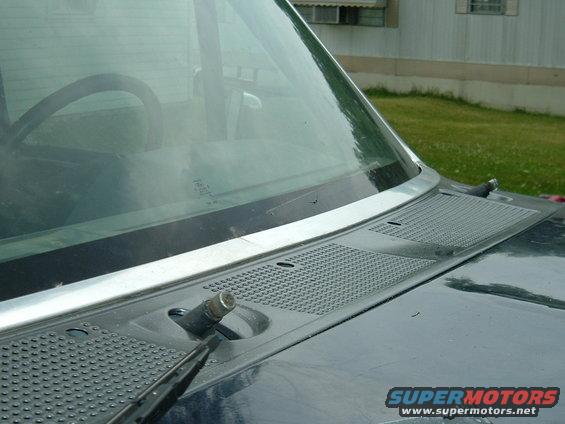 Close-up of a car's windshield wiper base and cowl area