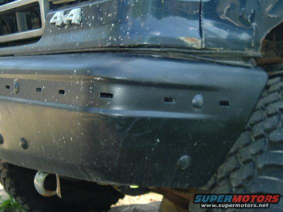 Close-up of a dark SUV's front bumper with '4x4' badge visible on the fender