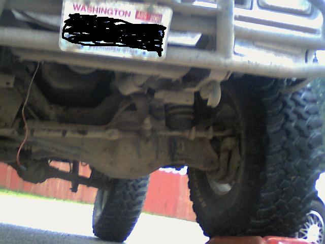 Undercarriage view of a lifted 4x4 with large tires and a Washington license plate