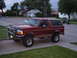 1994 Ford Bronco - This 1994 Ford Bronco is shown in a three-quarter front view, parked on a residential driveway.
