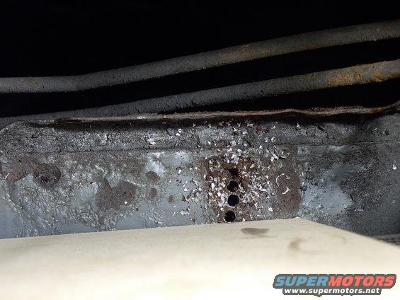 img_0054.jpg The slot holes for the "tabs" carved out of the angle iron were made crudely, but effectively the old fashioned way by connecting the holes you see drilled here.