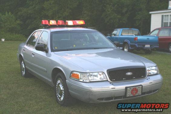 Silver 1998 Ford Crown Victoria police car with light bar