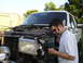 1990 Ford Bronco - A man works on the front end of a 1990 Ford Bronco, which appears to be undergoing a front-end swap.
