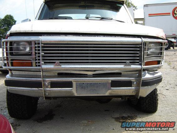 White Ford Bronco with chrome grille guard, front view. Damaged grille