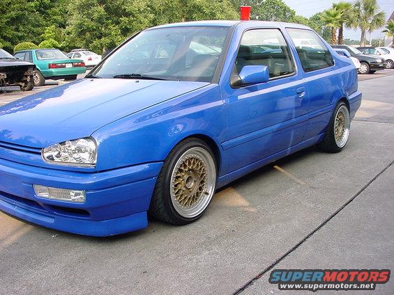 Blue Volkswagen Golf Mk3 with gold mesh wheels, lowered suspension, and aftermarket body kit