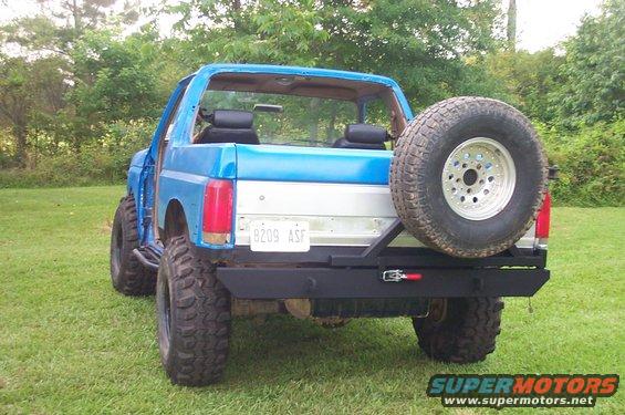 Blue Ford Bronco with a rear-mounted spare tire and aftermarket bumper