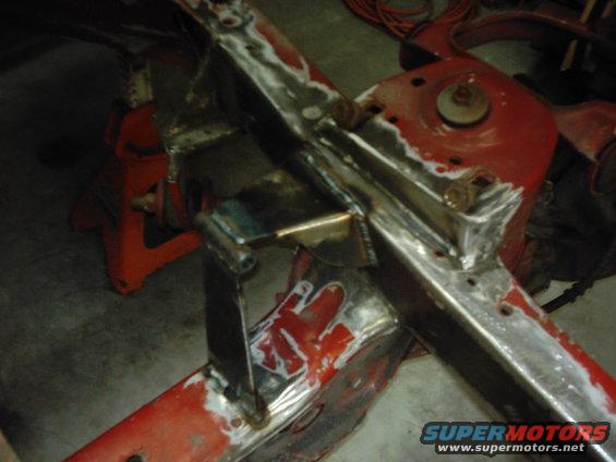 Welded metal frame sections on red jack stands, undergoing repair