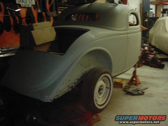 1936 coupe body on jack stands in a workshop, undergoing restoration