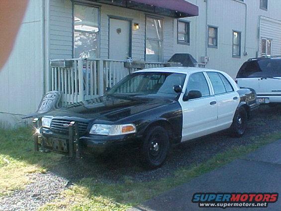 Two-tone police car parked in front of a building, another SUV behind it