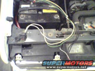 Engine bay with a black battery, wires, and part of an alternator