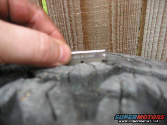 Close-up of tire tread with a razor blade