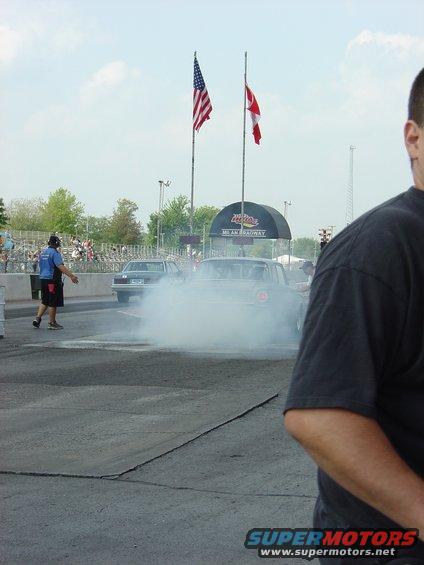 Rear view of a 1960 Ford Falcon doing a burnout