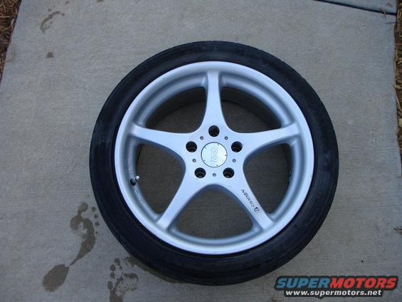 Silver 5-spoke aftermarket wheel with tire, center cap reads 'SSR'