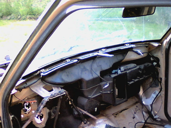 Interior of a vehicle with dashboard removed, showing wiring and HVAC components