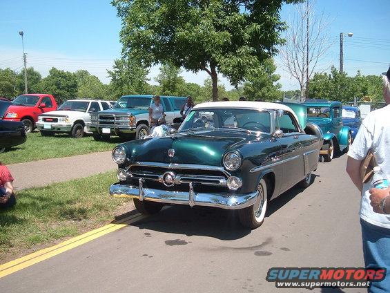 Green coupe with white roof, front view