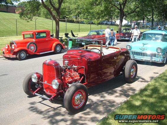 Red hot rod convertible with exposed engine and chrome grille